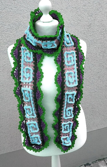 Gehäkelter Schal in Grün, Violett und Hellblau mit Spiralmuster an einer Schaufensterpuppe