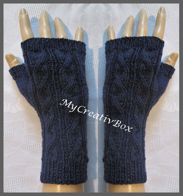Zwei dunkelblaue, fingerlose Armstulpen mit Zopfmuster auf Handmodellen.