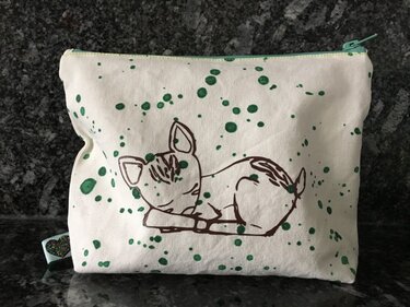 Weiße Stofftasche mit Linienzeichnung eines schlafenden Rehkitzes und grünen Farbsprenkeln