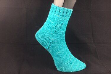 Türkise gestrickte Damensocke am Modellfuß mit Zopfmuster am Schaft