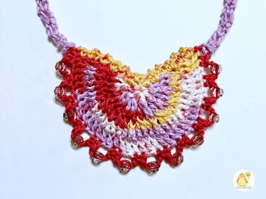 Halbkreisförmiges gehäkeltes Collier in Rot, Rosa und Gelbtönen mit Perlenkante und Band