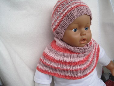 Babypuppe mit gestrickter Mütze und Schlupfschal in Rosa, Koralle und Grau