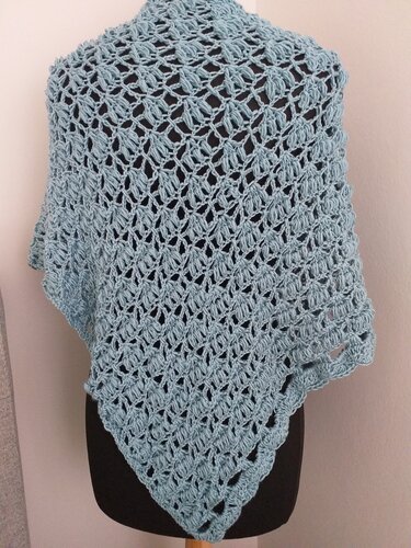 Hellblaues, gehäkeltes Dreieckstuch mit offenem Loch- und Reliefmuster auf einer Schneiderpuppe.