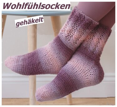 Zwei gehäkelte Wohlfühlsocken in rosa‑violetten Tönen mit Spitzenbündchen