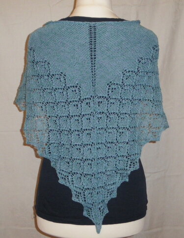 Gestricktes Dreieckstuch mit mittiger Lochreihe, Ajourmustern und gezacktem Rand auf einer Schaufensterpuppe