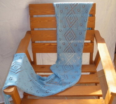 Hellblauer gestrickter Schal mit Ajour-Diamantmuster auf Holzstuhl