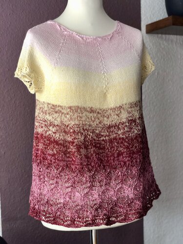 Gestricktes Damen-Raglanshirt in Rosé, Gelb und Rot mit zarter Spitzenborte am Saum auf einer Schneiderpuppe