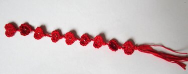 Rotes gehäkeltes Lesezeichen mit Blüten, Perlen und Quaste