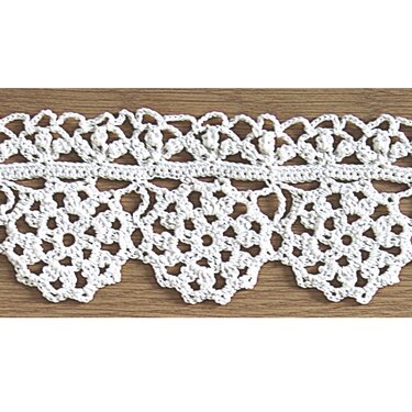 Weiße gehäkelte Spitzenborte mit Blumenmotiven und gezacktem Rand auf Holzuntergrund