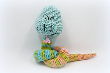 Nahaufnahme einer gehäkelten Amigurumi‑Schlange mit gestreiftem Körper