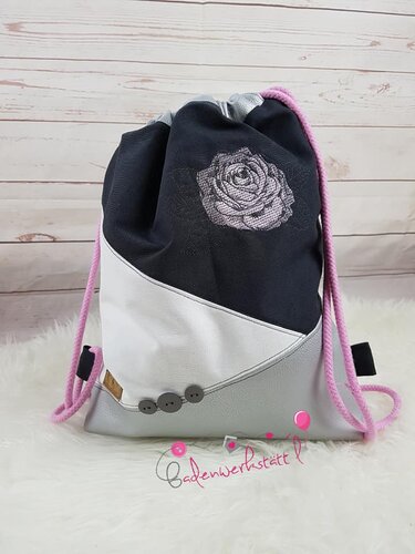 Kordelrucksack in schwarz, weiß und hellgrau mit rosa Kordeln, gestickter Rose und drei grauen Knöpfen