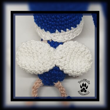 Nahaufnahme eines gehäkelten Objekts mit weißen Flügeln und blauem Körper