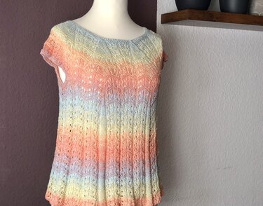 Gestrickte pastellfarbene Tunika mit Lochmuster auf Schaufensterpuppe