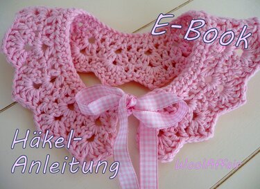 Rosa gehäkelter Babykragen mit Lochmuster und rosa-weiß kariertem Band in Schleife auf hellem Untergrund
