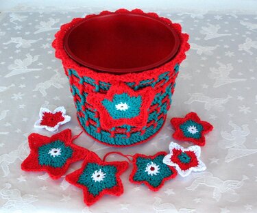 Gehäkelter Übertopf in Rot, Türkis und Weiß mit markanter Sternapplikation und losen Sternen