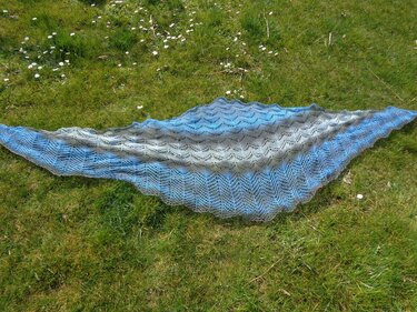 Gestricktes Dreieckstuch Blau-Grau mit Lochmuster auf Gras