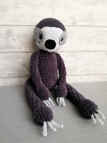 Gehäkeltes Faultier-Amigurumi in Dunkellila und Hellgrau, sitzend