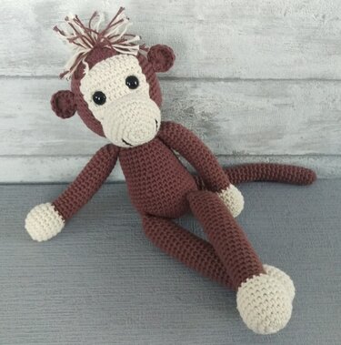 handgehäkelter Amigurumi-Affe braun mit cremefarbenem Gesicht und schwarzen Augen