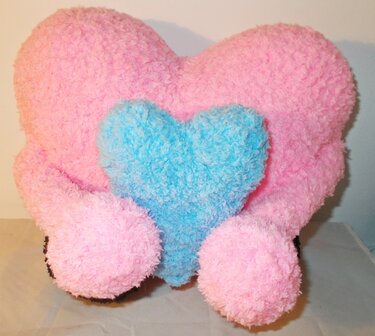 Rosa gehäkeltes Herz-Kissen mit kleinem blauem Herz in der Mitte