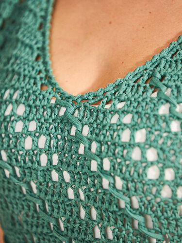 Nahaufnahme des V-Ausschnitts eines türkisen Häkeltops mit offenem Muster