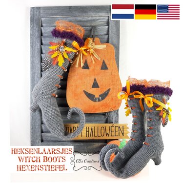 Pair of gray crocheted witch boots with curled toes, orange ribbons and purple trim beside a wooden jack-o'-lantern