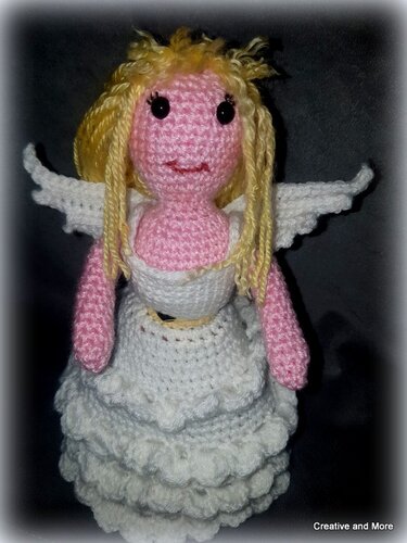 Gehäkelte Amigurumi-Engelpuppe mit gelben Haaren, weißen Flügeln und mehrlagigem Rüschenkleid