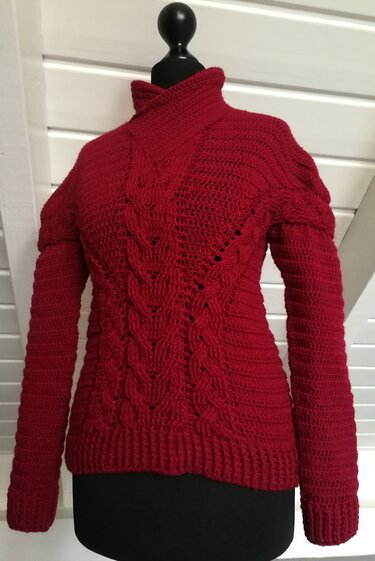 Roter gehäkelter Damenpullover auf Schneiderpuppe mit Zopfmuster und Stehkragen