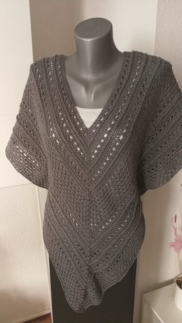 Grau gehäkelter Poncho mit V-Ausschnitt auf Mannequin