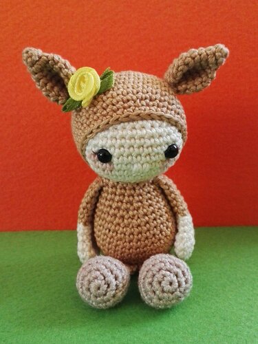 Gehäkelte Amigurumi-Puppe in Braun mit Reh-Ohren und gelber Blüte