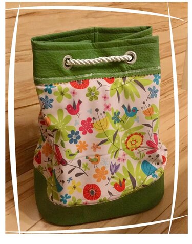 Zugtasche mit Vögeln und Blumenmuster auf Holzboden