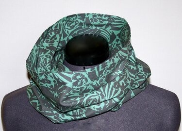 Teal and dark gray patterned infinity scarf doubled into a cowl on a mannequin, highlighting drape and fabric