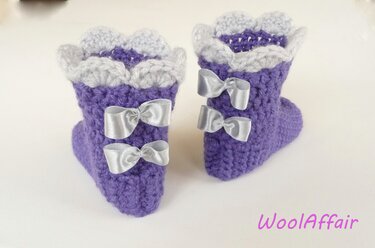 Lila gehäkelte Baby-Booties mit Rüschensaum und Schleifen
