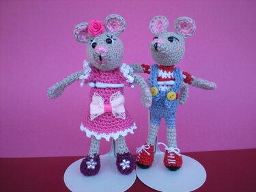 Gehäkeltes Amigurumi‑Mäusepaar: Mädchen in Rosa und Junge in Blau vor rosa Hintergrund
