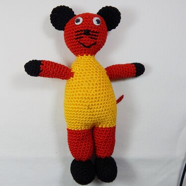 Gehäkelte Amigurumi‑Maus in Rot und Gelb mit schwarzen Akzenten, stehend