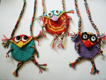 Drei verspielte, gehäkelte Eulen-Umhängetaschen in leuchtenden Farben mit Fransen