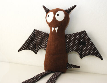 Braunes Fledermaus-Kuscheltier mit gepunkteten Flügeln und langen Beinen