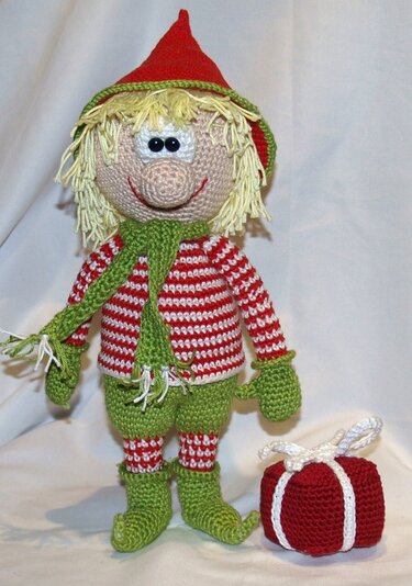 Gehäkelter Elf in Rot und Grün mit Zipfelmütze, Schal und Geschenk
