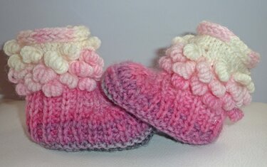 rosa gestrickte Babyschuhe mit geripptem Fuß und Noppenbündchen
