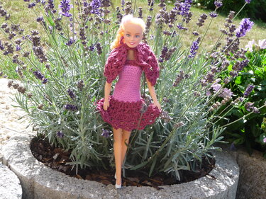 Puppe in gehäkeltem rosa Kleid und himbeerfarbenem Bolero, mit Fokus auf Maschenbild