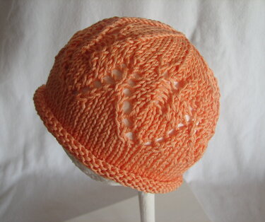 Apricotfarbene gestrickte Babymütze mit Ajourmuster und umgeschlagenem Rand