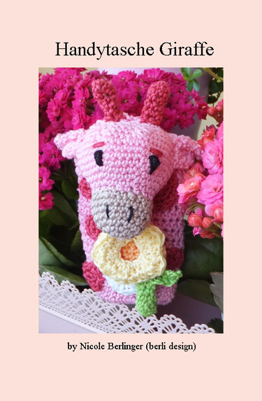 Rosa gehäkelte Handytasche in Giraffenform mit gelber Blüte vor pinken Blumen