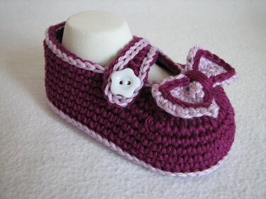 Gehäkelter Babyschuh beere mit hellrosa Kante, Riemen und Schleife