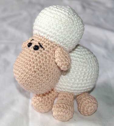 Gehäkeltes Amigurumi-Schaf in Weiß und Beige mit schwarzen Augen