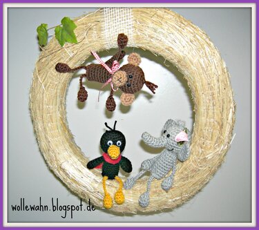 Strohkranz mit drei gehäkelten Amigurumi-Tieren: Affe, Vogel und Elefant