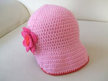 Rosa gehäkelter Kinderhut mit pinker Blüte und kontrastierendem Rand