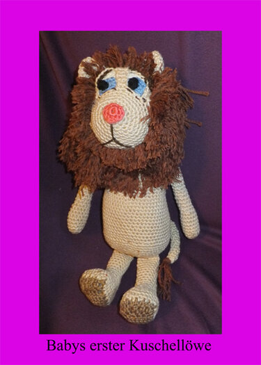 Sitzender handgehäkelter Amigurumi‑Löwe mit brauner Mähne, beigem Körper und rosa Nase.