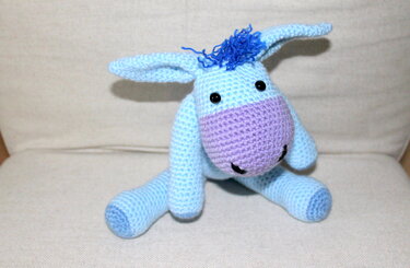 hellblauer gehäkelter Amigurumi‑Esel mit lila Schnauze und schwarzen Augen