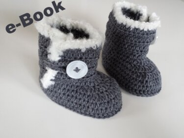 Zwei graue gehäkelte Babystiefel mit weißem Plüschfutter und weißen Knöpfen auf hellem Hintergrund.