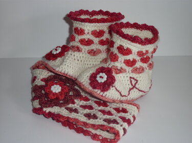 Gehäkelte creme-rote Babyschuhe mit passendem Stirnband und Herz- sowie Blumenapplikationen