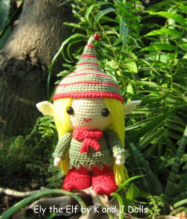 Gehäkelte Amigurumi-Wichtel-Puppe mit gestreifter Zipfelmütze, langen gelben Haaren und roten Stiefeln
